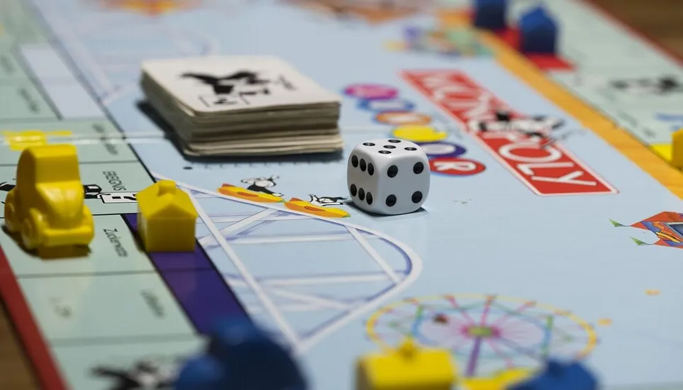 Dadi del Monopoli e segnalino accanto al tabellone durante una partita