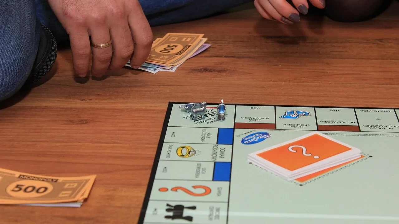 Tabellone classico del Monopoli con casette rosse, dadi e segnalini metallici