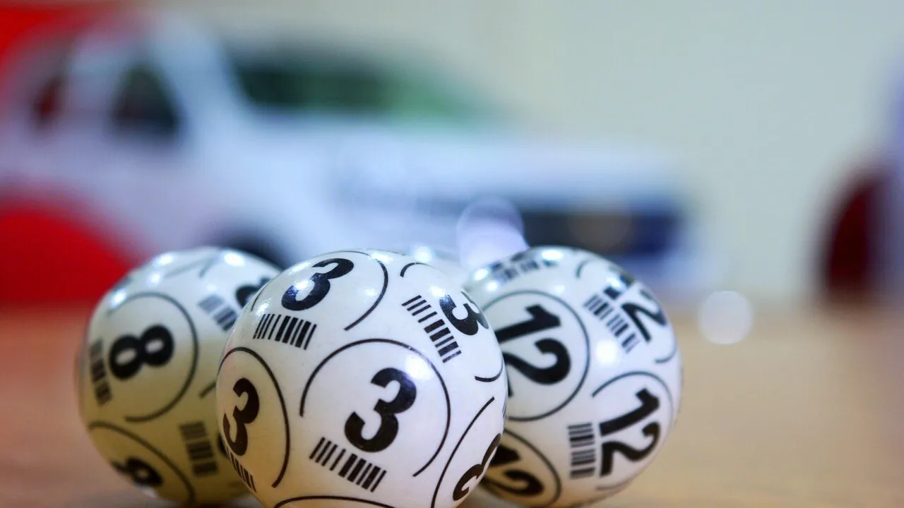 Palline numerate per estrazione del Lotto su sfondo nero con luci dorate